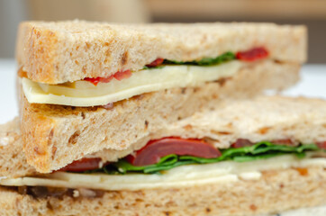 Closeup on a vegetarian sandwich with cheddar cheese, tomato, spinach with mango and apricot chutney in seeded malted bread