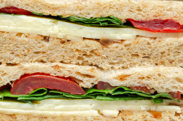Closeup on a vegetarian sandwich with cheddar cheese, tomato, spinach with mango and apricot chutney in seeded malted bread