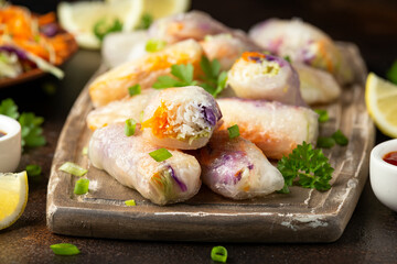Fried Vegan spring rolls, rice paper dumplings with sweet and purple cabbage, rice noodles and carrots