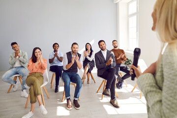 Group of satisfied diverse women and men applaud female coach on corporate business. Unrecognizable...