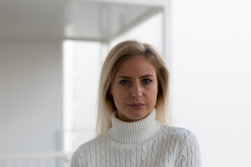 Schöne Blonde Frau in weißen Pullover Zuhause
