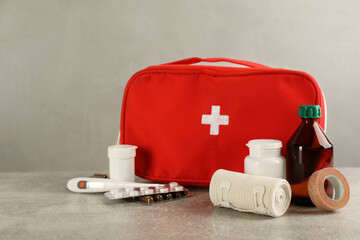 First aid kit on grey table. Space for text