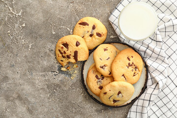 Delicious homemade cookies with chocolate chips and glass of milk on grey background