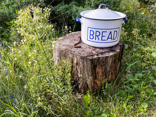 White pot titled 'bread' on a chopping block
