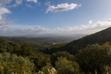 Fototapeta premium Blick in die Landschaft mit Hügeln, Wolken und Sonne von Sasseta, Italien, Toskana