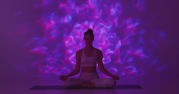 Yoga Practice. Yogi Girl Sitting In Lotus Pose Meditate For Wellness, Healthy Aura In Purple Light With Esoteric Pattern