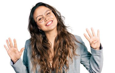 Young hispanic girl wearing business clothes and glasses showing and pointing up with fingers number nine while smiling confident and happy.