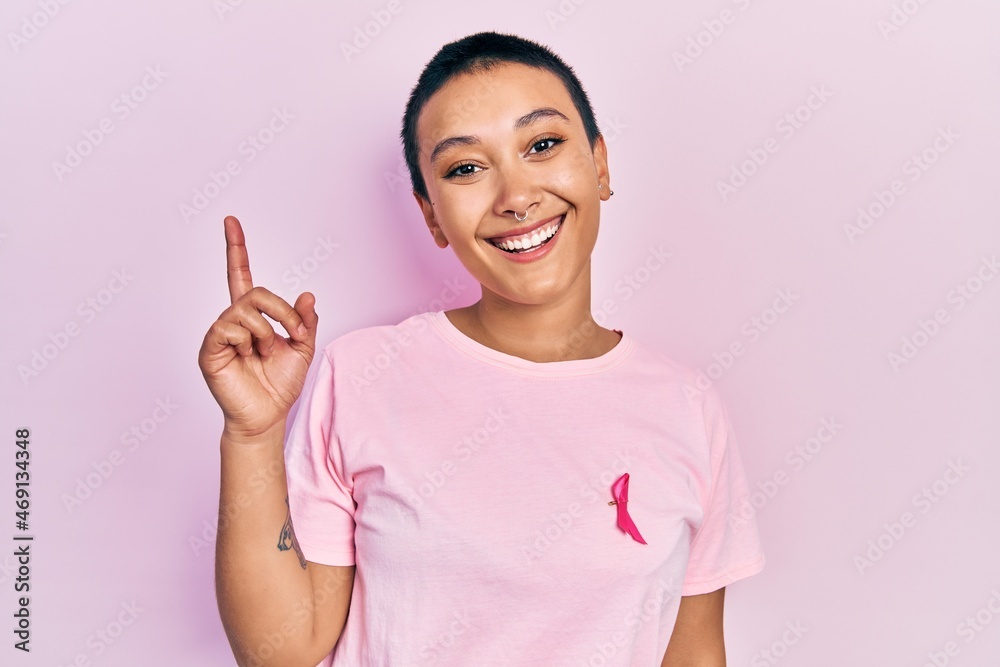 Sticker beautiful hispanic woman with short hair wearing pink cancer ribbon on shirt surprised with an idea 