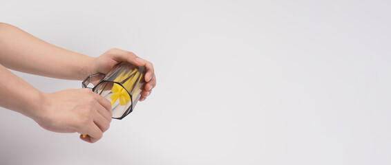 Clean and wash dish concept. Man hand washing drink glass on white background. Used drinking glass cleaning by soft yellow sponge stick. Wash cup by sponge brush. Disinfection hyginic in covid 19 era