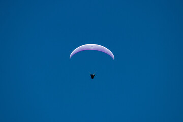 single person paragliding open clear sky blue background Pokhara 