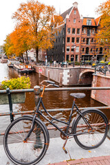 Fototapeta premium Abandoned city bike parked on a brdige over a canal in Amsterdam