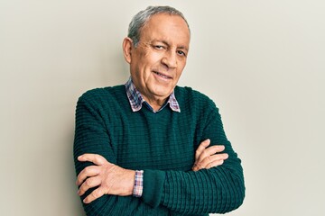 Handsome senior man with grey hair wearing casual sweater happy face smiling with crossed arms looking at the camera. positive person.