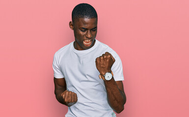 Young african american man wearing casual white t shirt celebrating surprised and amazed for...