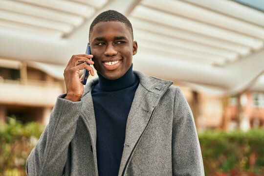 Young african american man smiling happy talking on the smartphone at the city