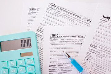tax forms 1040 with pen and calculator.
