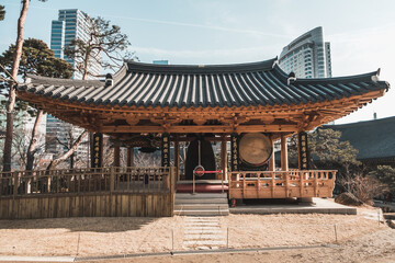 Traditional Asian temple with big roof in metropolis. skyscrapers on the background. Sunny day