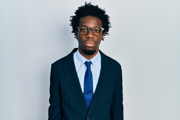 Young african american man wearing business suit with serious expression on face. simple and...