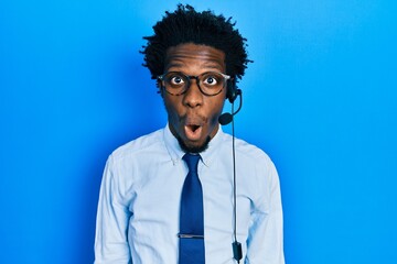 Young african american man wearing call center agent headset scared and amazed with open mouth for surprise, disbelief face