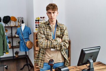 Young caucasian man working as manager at retail boutique skeptic and nervous, disapproving...