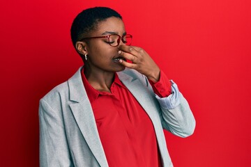 Young african american woman wearing business jacket and glasses smelling something stinky and disgusting, intolerable smell, holding breath with fingers on nose. bad smell