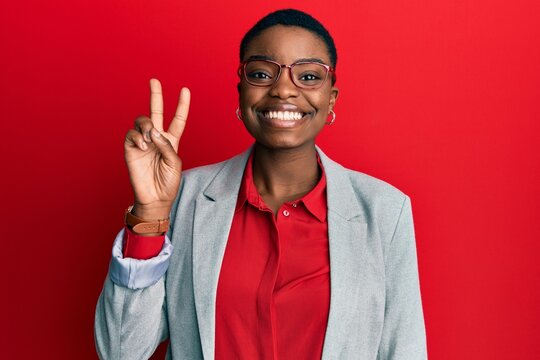 Young african american woman wearing business jacket and glasses showing and pointing up with fingers number two while smiling confident and happy.
