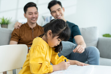 Asian attractive LGBTQ gay family teach young girl kid draw picture. 