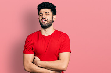 Young arab man with beard wearing casual red t shirt with hand on stomach because nausea, painful disease feeling unwell. ache concept.