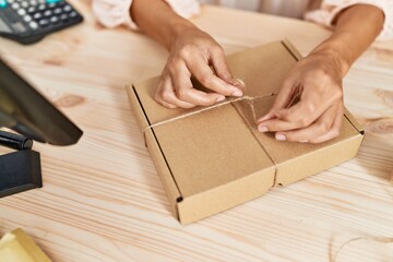 Young hispanic woman packing order at storehouse