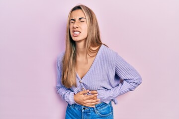 Beautiful hispanic woman wearing casual shirt with hand on stomach because nausea, painful disease feeling unwell. ache concept.