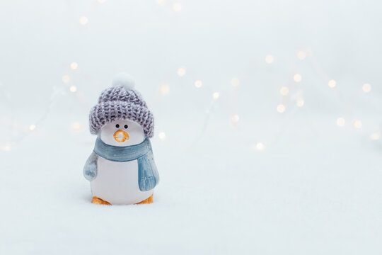Decorative Christmas-themed figurines. The statuette of a penguin in a knitted hat on the white background.