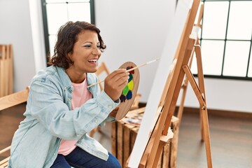 Fototapeta na wymiar Middle age hispanic artist woman smiling happy drawing at art studio.