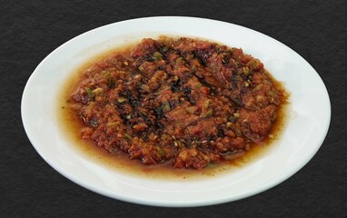 Traditional Turkish Appetizer Acili Ezme. Turkish meze Acuka made with fresh tomatoes, green pepper, cucumber and spices. Traditional Turkish Appetizer Acili Ezme served on plate on black background
