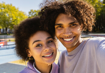 Interracial young couple dating outdoors, colored and modern urban background