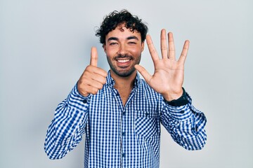 Young hispanic man wearing casual clothes showing and pointing up with fingers number six while smiling confident and happy.