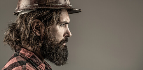 Man builders, industry. Builder in hard hat, foreman or repairman in the helmet. Building, industry, technology - builder concept. Bearded man worker with beard in building helmet or hard hat