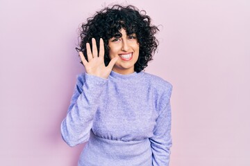 Fototapeta na wymiar Young middle east woman wearing casual clothes showing and pointing up with fingers number five while smiling confident and happy.