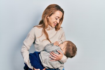Young caucasian woman holding and hugging her son breastfeeding him, maternity lactation - obrazy, fototapety, plakaty