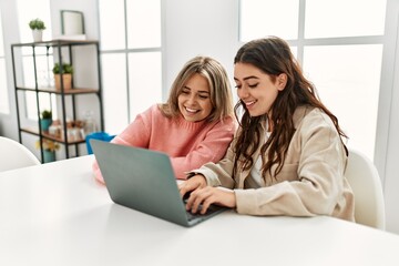 Young couple smiling happy working using laptop at home.