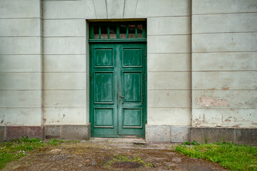 Close-up of old wooden door in summer time. Green door in stone palace wall.