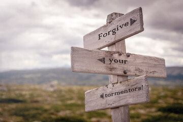 forgive your tormentors text on wooden sign outdoors in nature. Religious and christianity quotes.