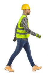 Walking construction worker, side view. Studio shot on white background. - 469148540