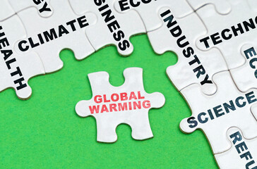 On a green background, white puzzles with text, a puzzle with the inscription - Global Warming