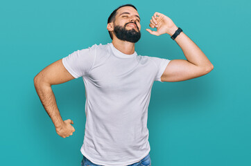 Young man with beard wearing casual white t shirt stretching back, tired and relaxed, sleepy and yawning for early morning