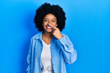 Fototapeta na wymiar Young african american woman wearing casual clothes pointing with hand finger to face and nose, smiling cheerful. beauty concept