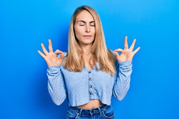 Young caucasian woman wearing casual clothes relax and smiling with eyes closed doing meditation gesture with fingers. yoga concept.