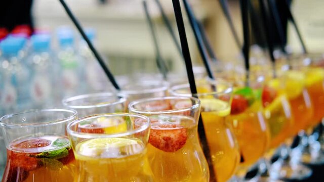 The waiter inserts straws into fruit lemonade