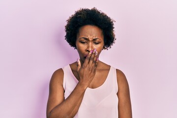 Fototapeta na wymiar Young african american woman wearing casual sleeveless t shirt bored yawning tired covering mouth with hand. restless and sleepiness.