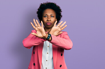 African american woman with afro hair wearing business jacket rejection expression crossing arms...