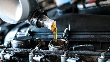 Close up of pouring synthetic motor oil in diesel engine.