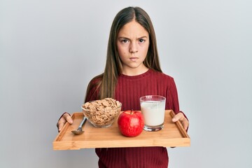 Beautiful brunette little girl holding tray with breakfast food skeptic and nervous, frowning upset because of problem. negative person.